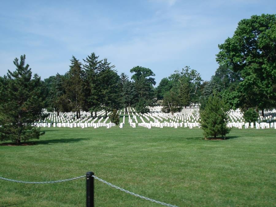 A cemetery with many white tombstones

AI-generated content may be incorrect.