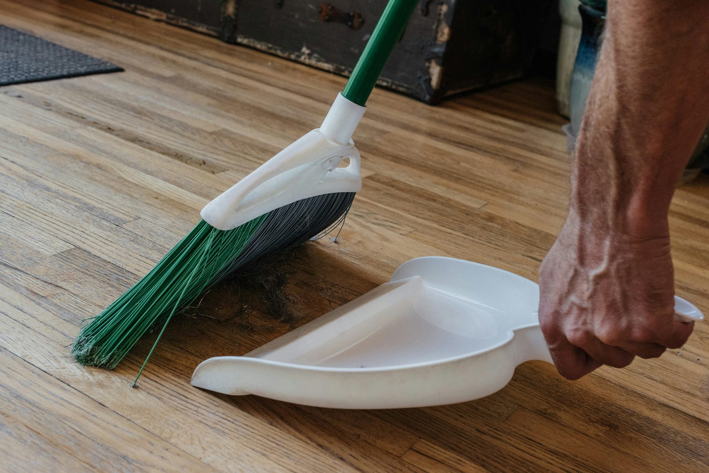 A man sweeping dirt into a dustpan.