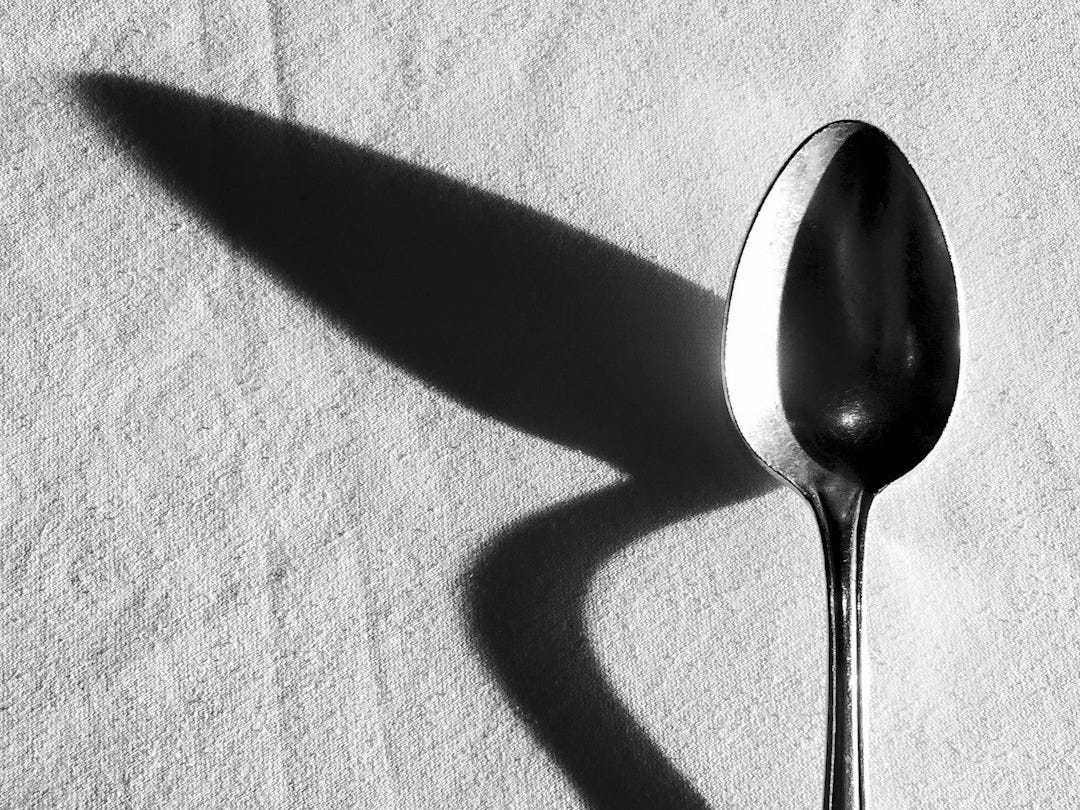 a spoon sitting on top of a white cloth a spoon sitting on top of a white cloth