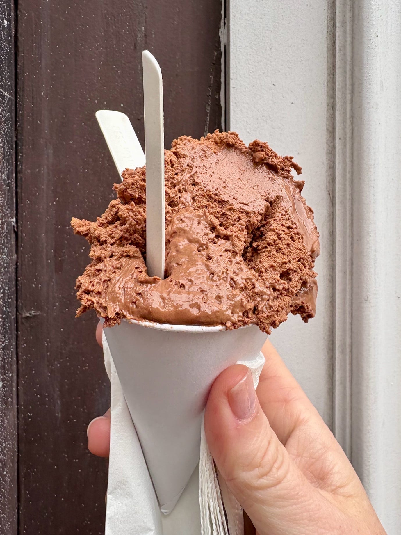A hand holding a chocolate ice cream cone

AI-generated content may be incorrect.