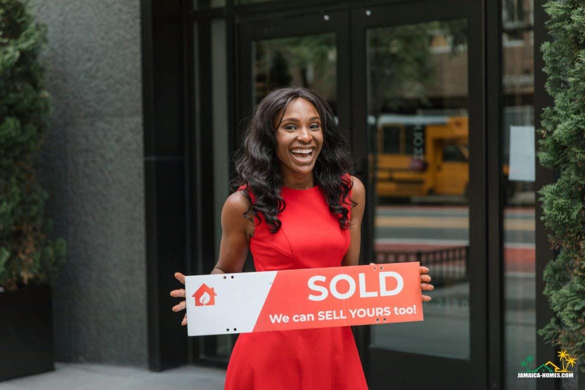 smiling woman holding sold sign outside real estate office