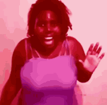 a woman in a pink tank top is waving her hand . a woman in a pink tank top is waving her hand .