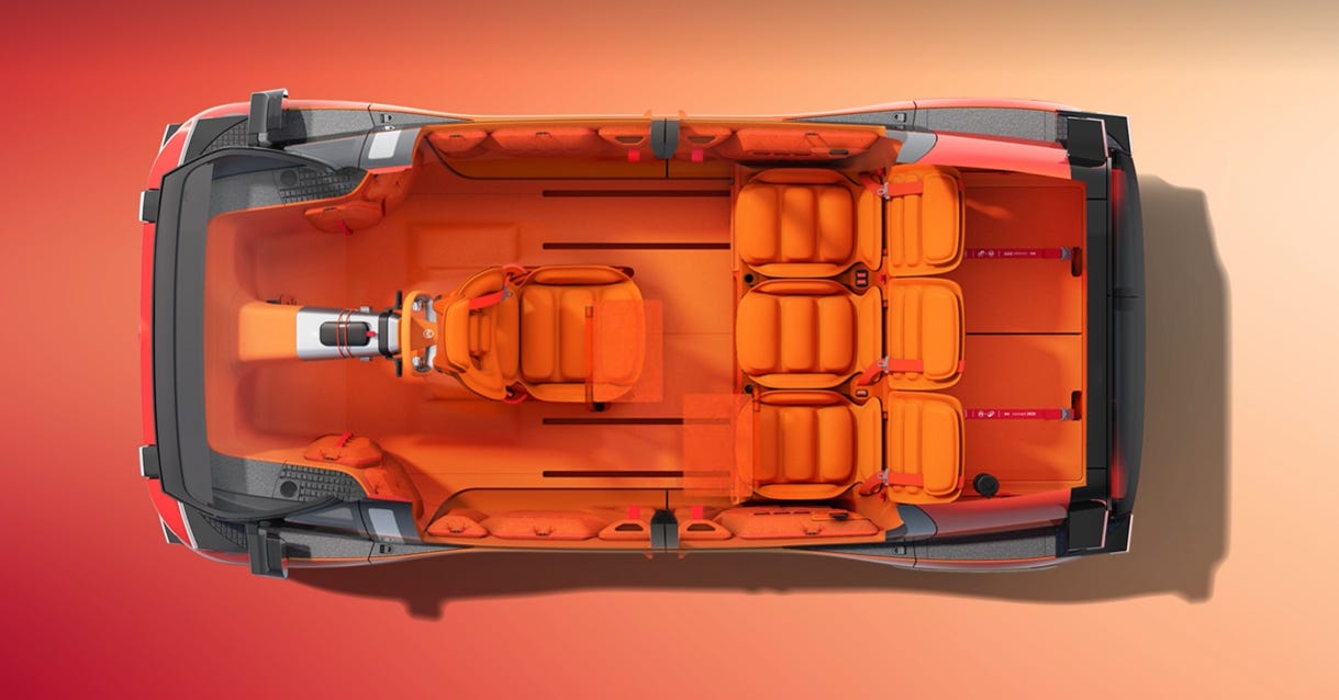 Top-down view of ELO concept showing orange interior with rotating driver seat, flexible seating arrangement, and wide pillar-free side opening. Top-down view of ELO concept showing orange interior with rotating driver seat, flexible seating arrangement, and wide pillar-free side opening.