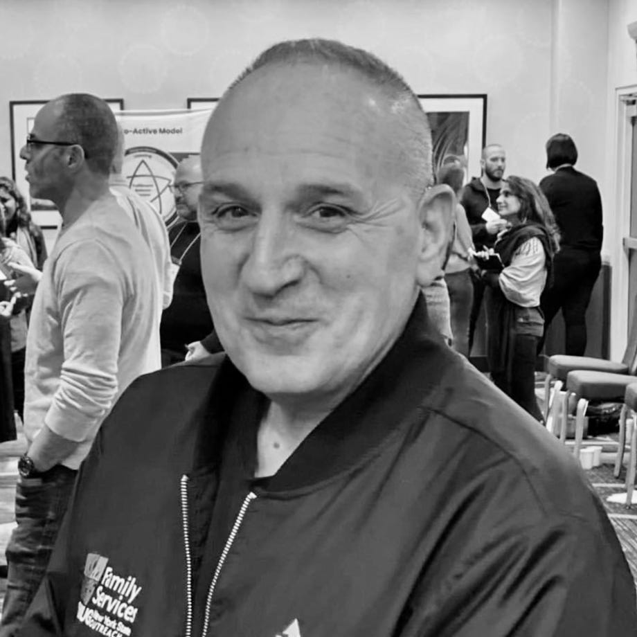 Black and white photo of Eric Kohner in front of coaching students talking. amongst themselves.