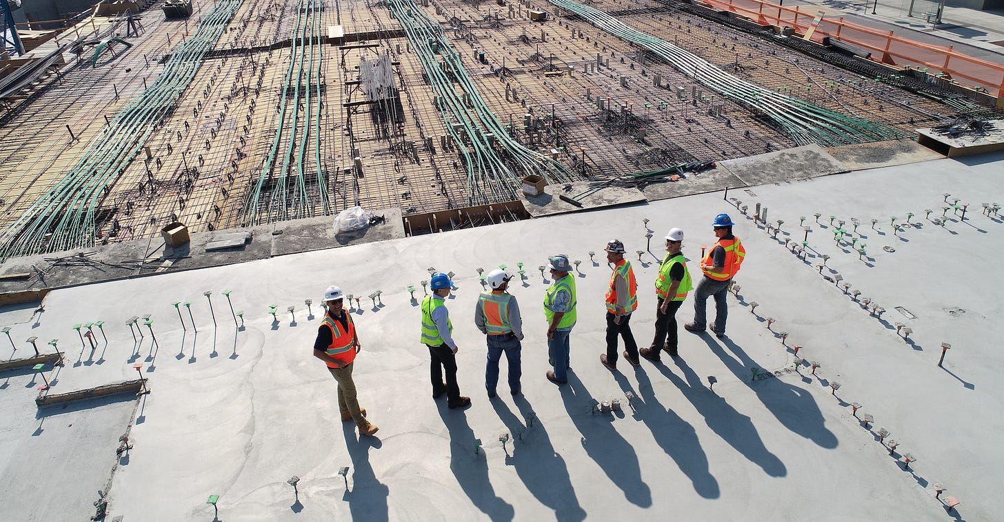 Construction workers look over huge construction site