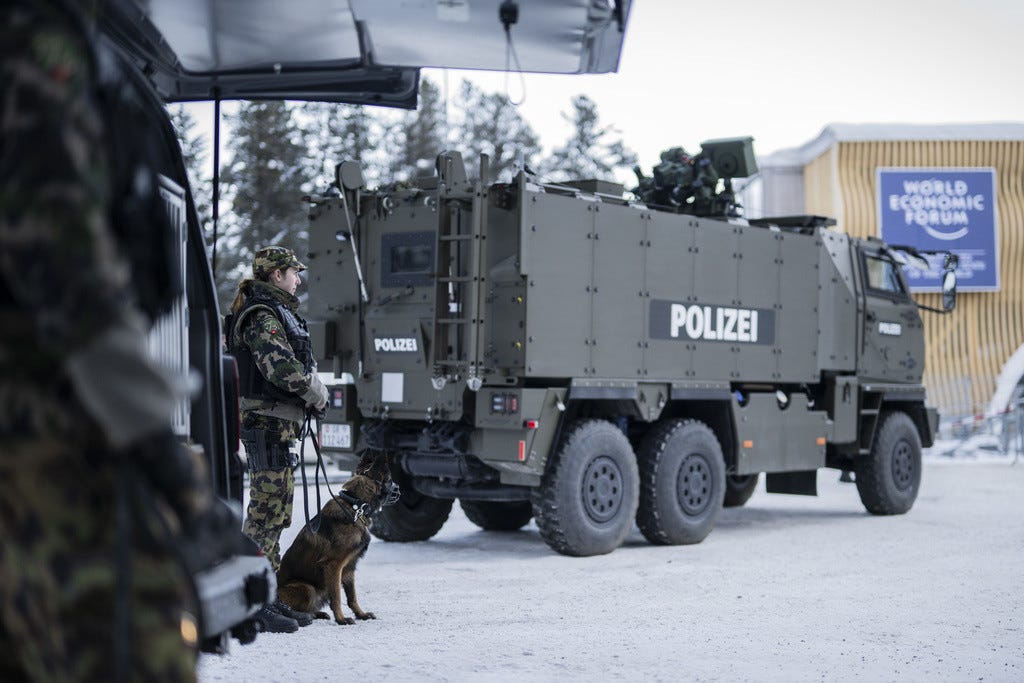 A soldier with canine and a armored vehicle are pictured during a press conference of police and army regarding security prior the 54th annual meeting of the World Economic Forum, WEF, in Davos, Switzerland, Friday, January 12, 2024. The meeting brings together entrepreneurs, scientists, corporate and political leaders in Davos under the topic "Rebuilding Trust" from 15 to 19 January. (KEYSTONE/Gian Ehrenzeller)