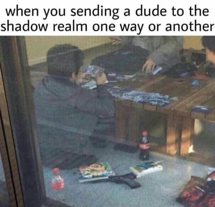 This may contain: two people sitting at a table with food on the floor and one person holding a cell phone