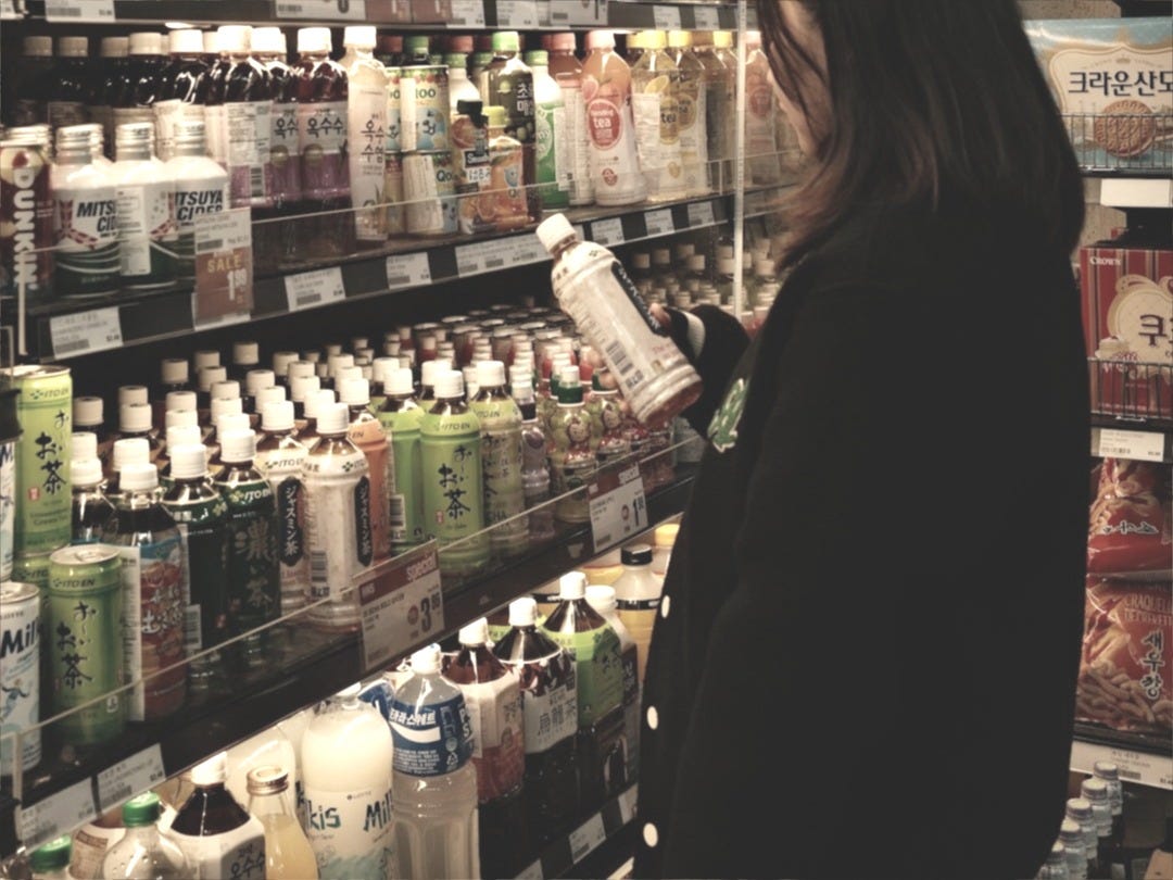 A woman standing in front of a display of drinks