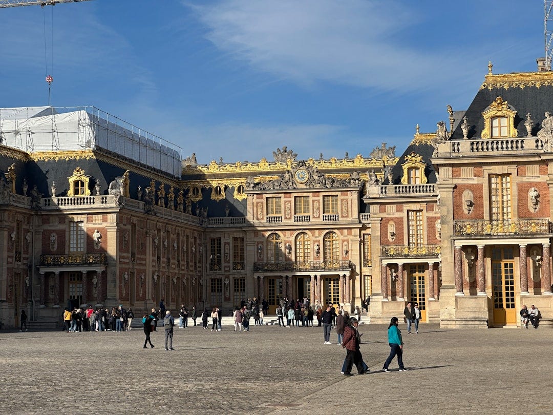 a group of people walking in front of a large building a group of people walking in front of a large building
