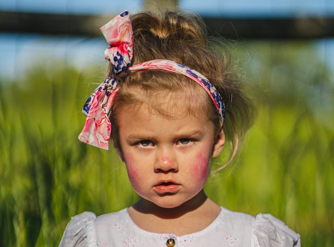 Young girl with pink stain on white dress