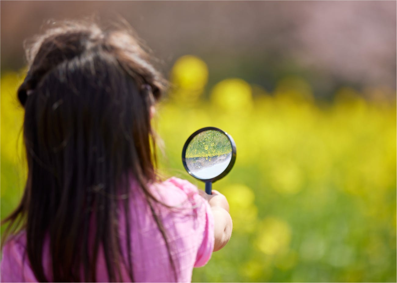 child holding magnifying glass