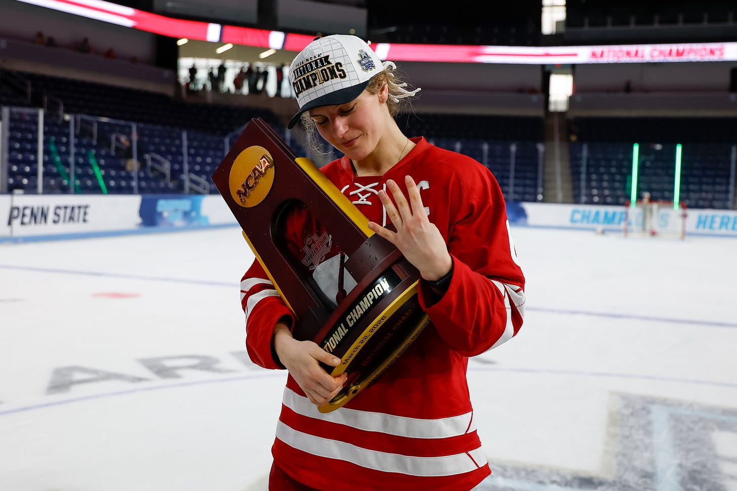 Lacey Eden holds a national championship trophy while holding up four fingers