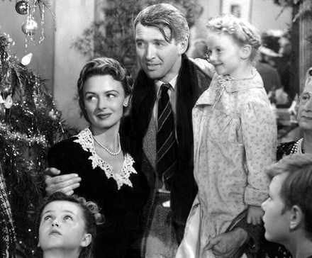 A group of people gathered around inside a house with Christmas decorations in It's A Wonderful Life