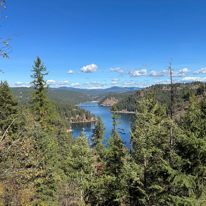 State line sign in Idaho and pictures of lake Coeur D'Alene with water and trees