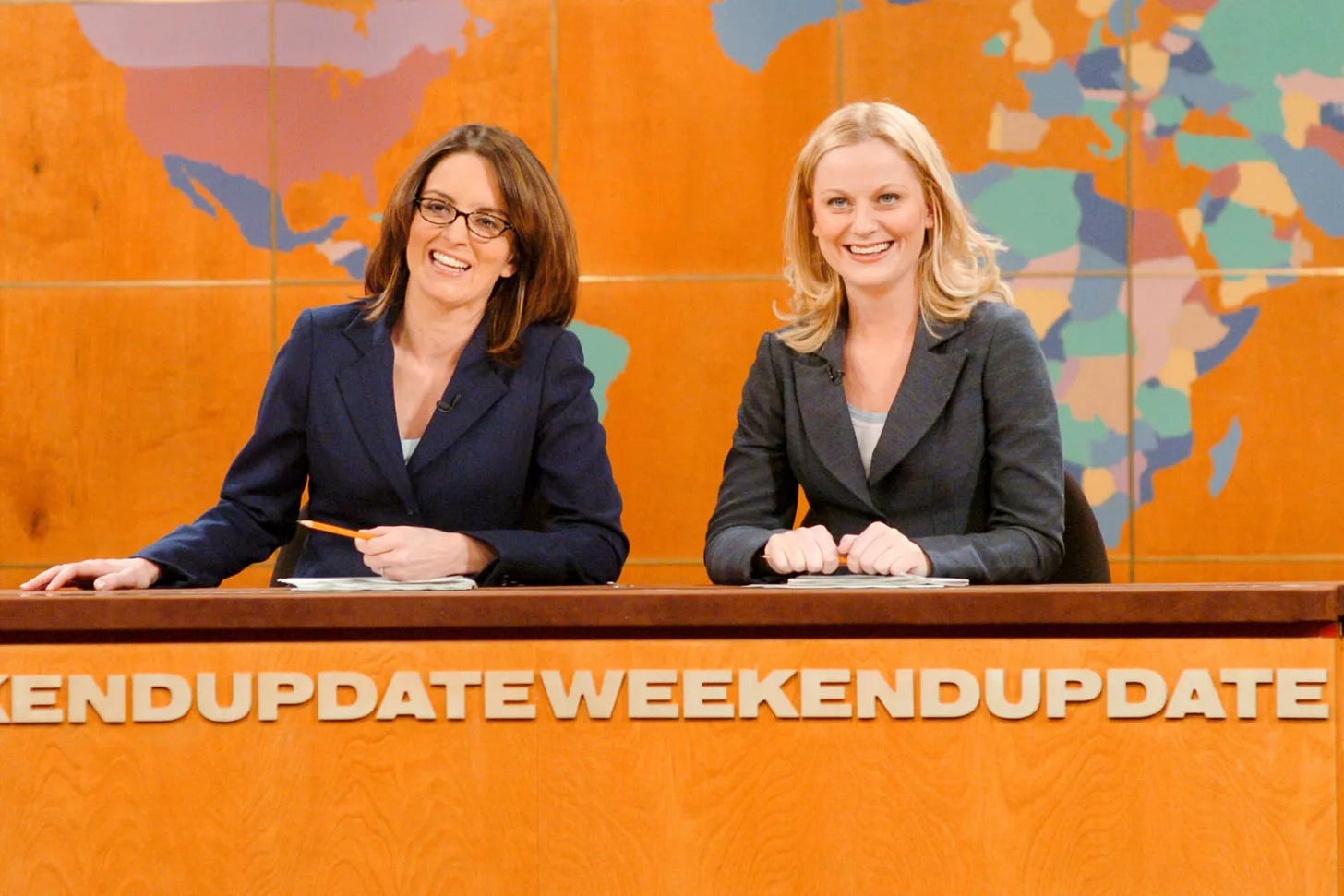 SATURDAY NIGHT LIVE -- Episode 7 -- Aired 12/11/2004 -- Pictured: (l-r) Tina Fey, Amy Poehler during "Weekend Update" (Photo by Dana Edelson/NBC/NBCU Photo Bank via Getty Images)