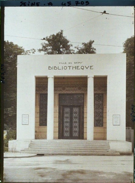 Entry portal to the old library in Reims. It is a white, cubic building in art deco style. 