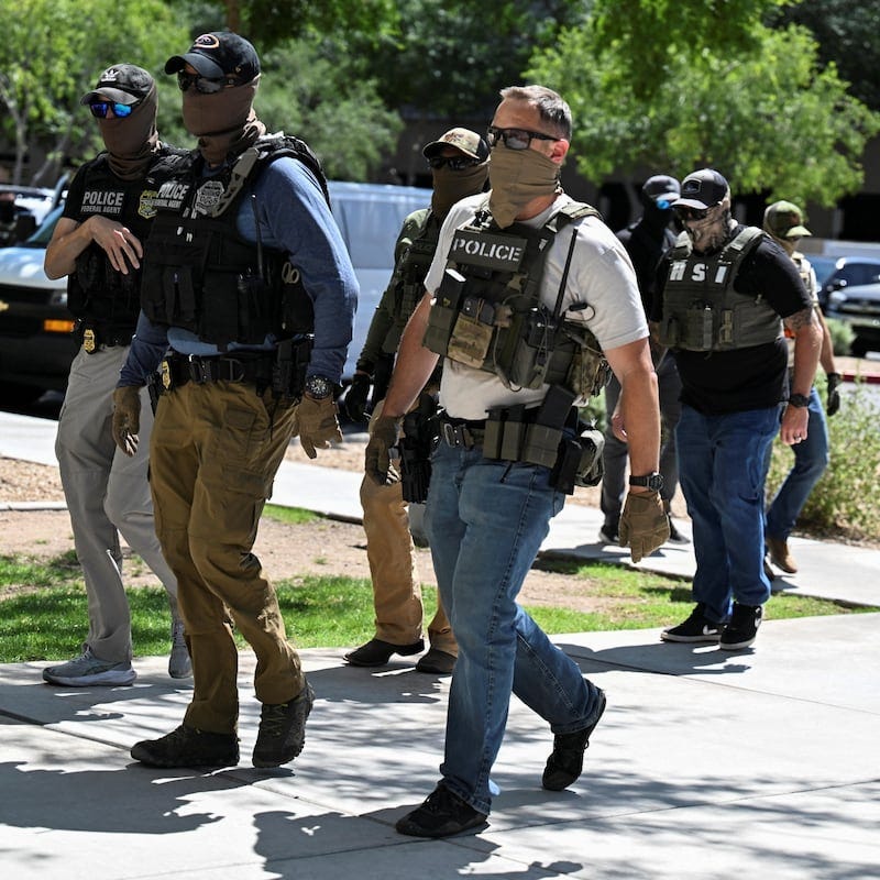 Masked law enforcement officers, including HSI and ICE agents, walk into an immigration court in Phoenix, Arizona, U.S., May 21, 2025.