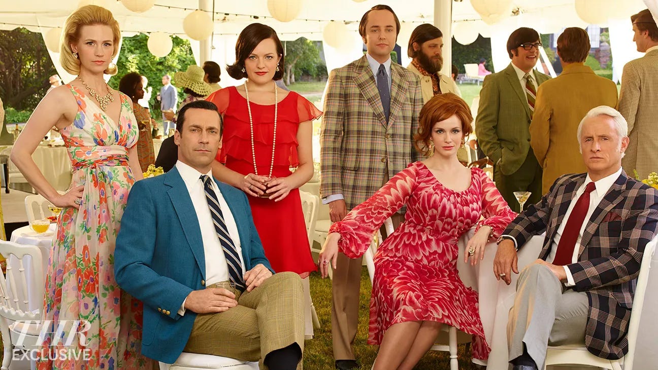 A cast photo of the main characters from Madmen. Jon Hamm, Christina Hendricks, John Slattery, January Jones, Elizabeth Olson, and Vincent Kartheiser.