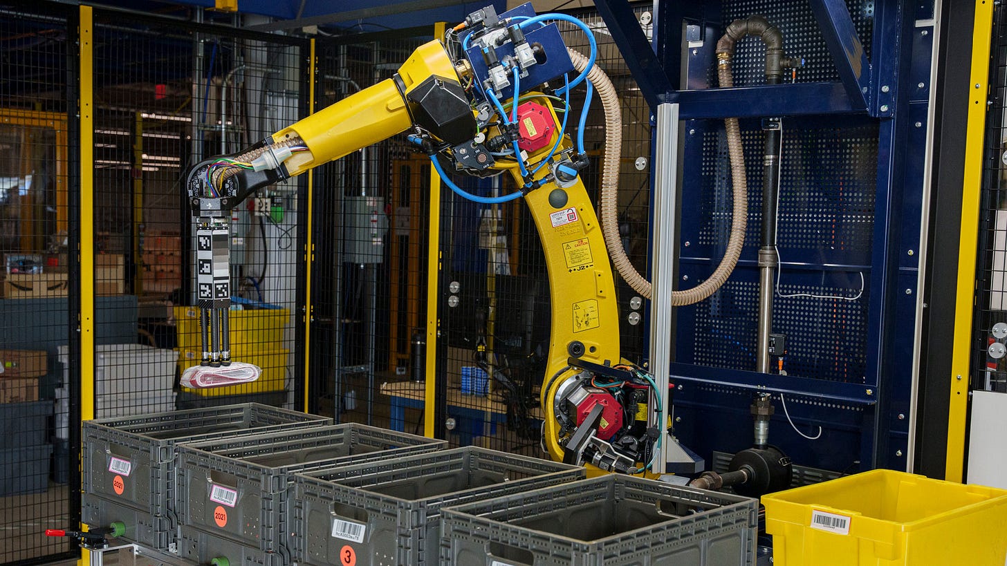 A robotic arm moves products from a bin in an Amazon fulfillment center.