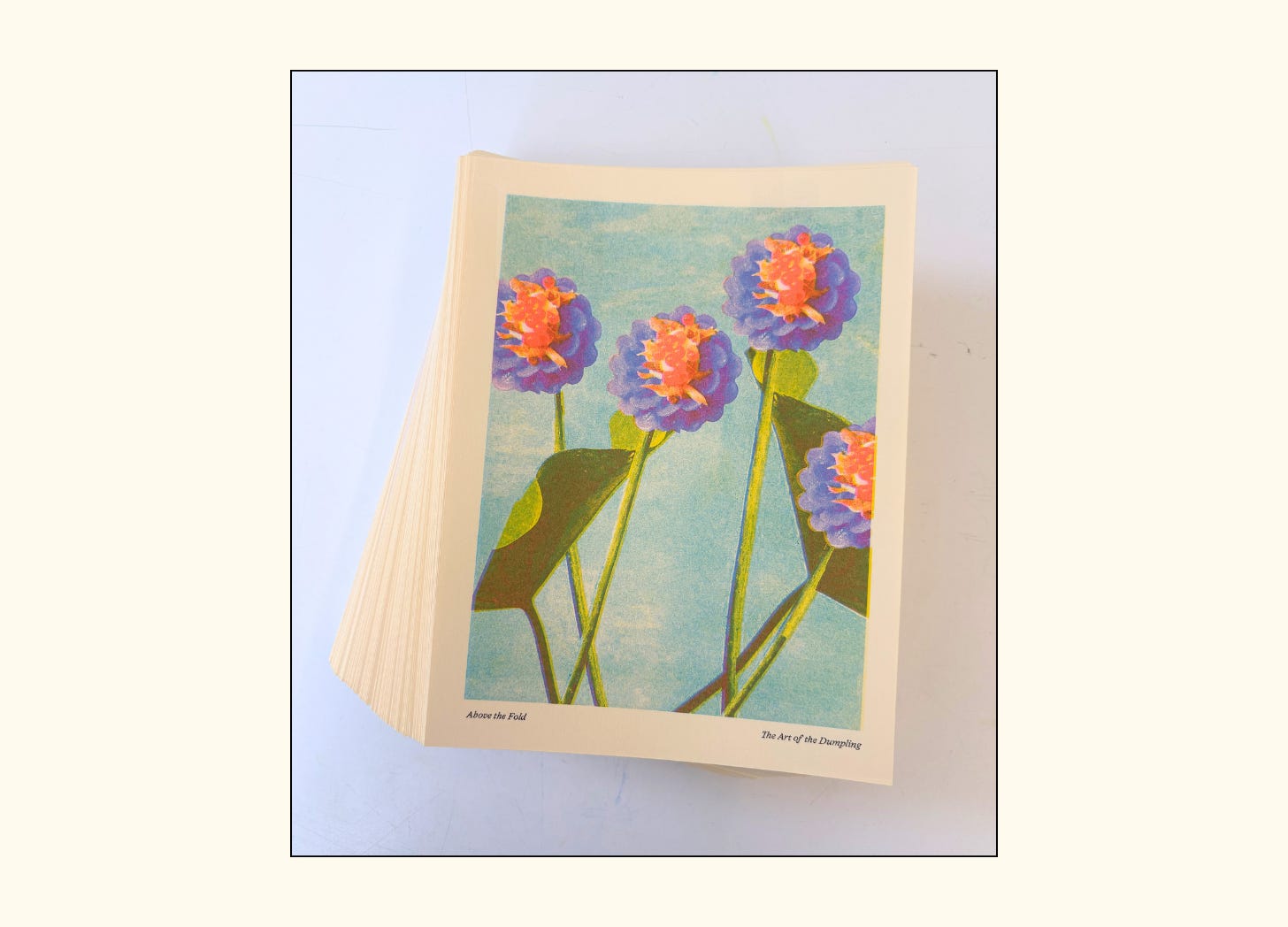 a stack of prints that show purple dumplings over green stems with a blue background