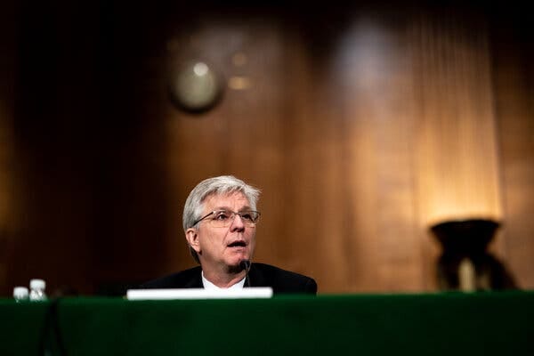 Christopher Waller speaking while seated behind a microphone during a Senate hearing.