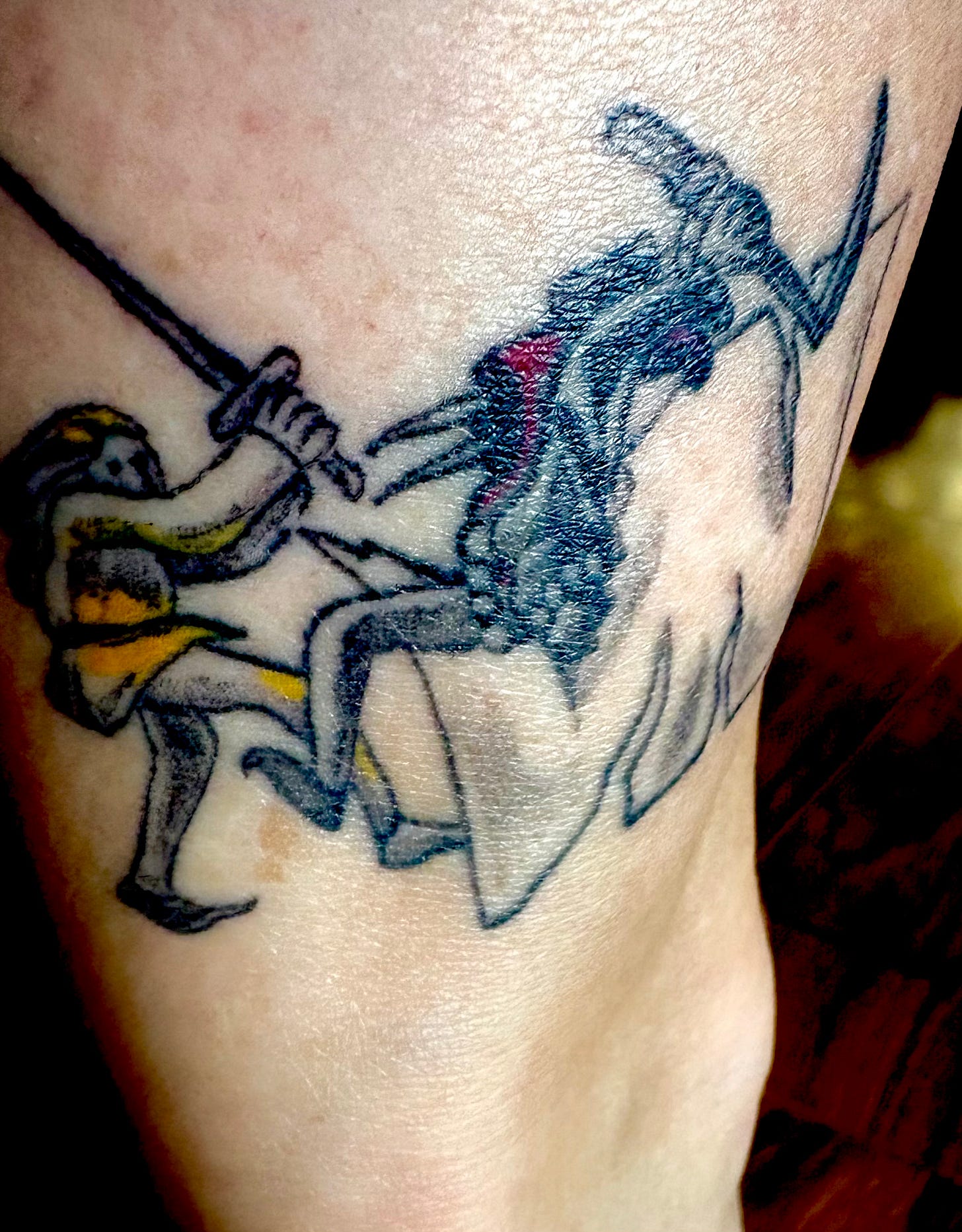 tattoo on white skin showing two figures in a sword fight