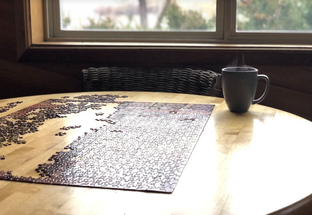 Cup of tea and puzzle on wooden table Cup of tea and puzzle on wooden table