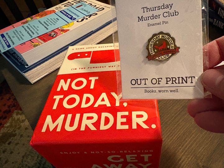 In these photos, we see the storefront display of Blue Heron Books in Uxbridge, Ontario, as well as a photo of Dinah's haul: two books, a table game called "Not Today, Murder" and a lapel pin for the Thursday Murder Club, Dinah's favourite mystery novel ever. These photos were take on an excursion during Rekindle Creativity Women's Writing Retreat in May 2026, which Dinah Laprairie cohosts with Liisa Kovala.