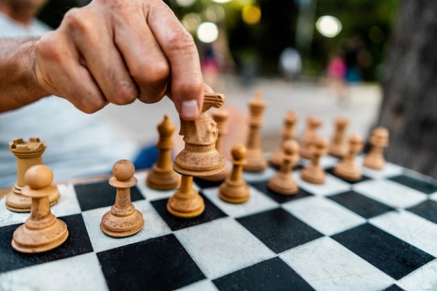 Close-up of a man playing chess board in the square