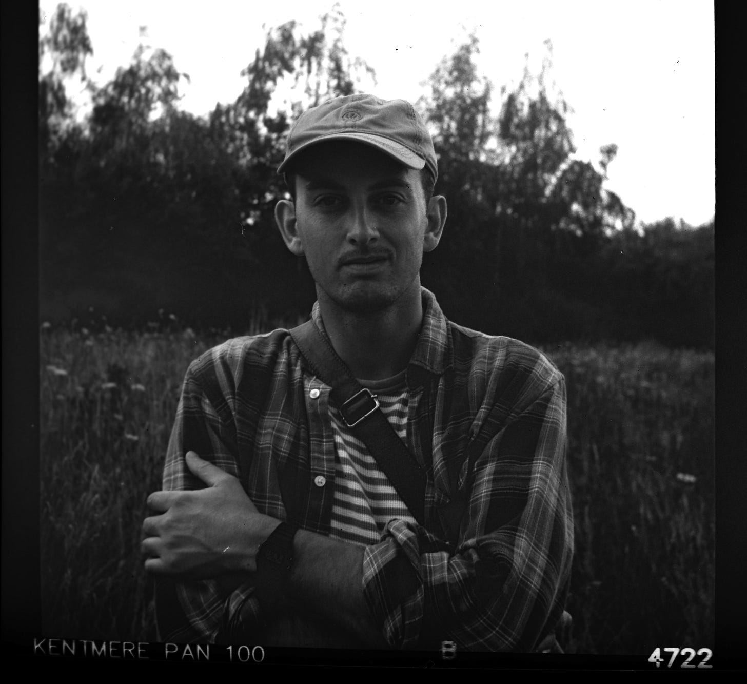 bw picture of Joe Pickard, white male, early 30s, standing in front of some trees