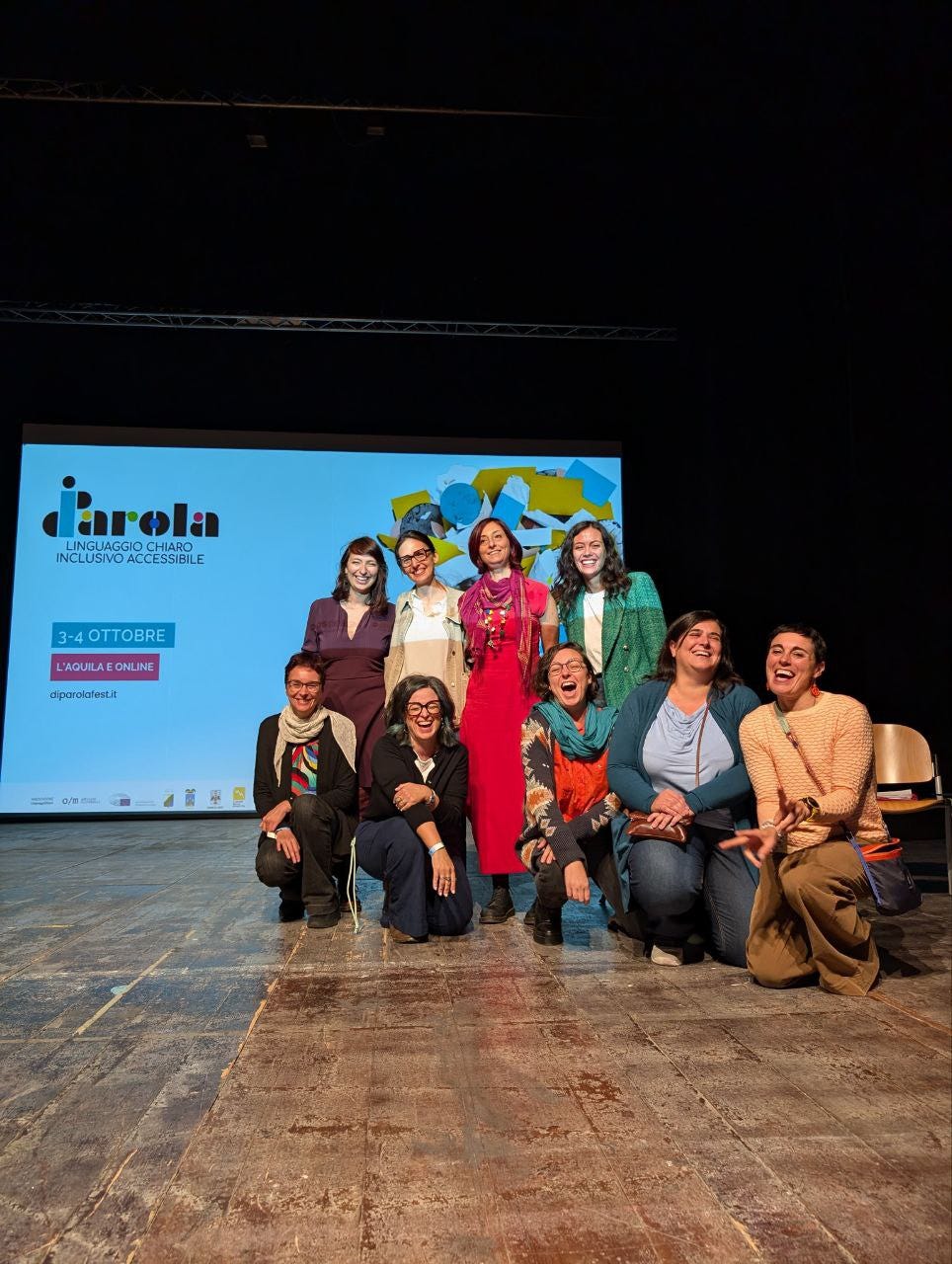 Foto di gruppo del team volontarie di DiParola Festival: Elena Panciera, Costanza Albè, Valentina Di Michele, Laura Lecci, Verusca Costenaro, Maria Elena Marras, Alice Orrù, Letizia Sechi, Roberta Zantedeschi. Nove strepitose donne sorridenti che si tengono strette sul palco del festival. Foto di gruppo del team volontarie di DiParola Festival: Elena Panciera, Costanza Albè, Valentina Di Michele, Laura Lecci, Verusca Costenaro, Maria Elena Marras, Alice Orrù, Letizia Sechi, Roberta Zantedeschi. Nove strepitose donne sorridenti che si tengono strette sul palco del festival.