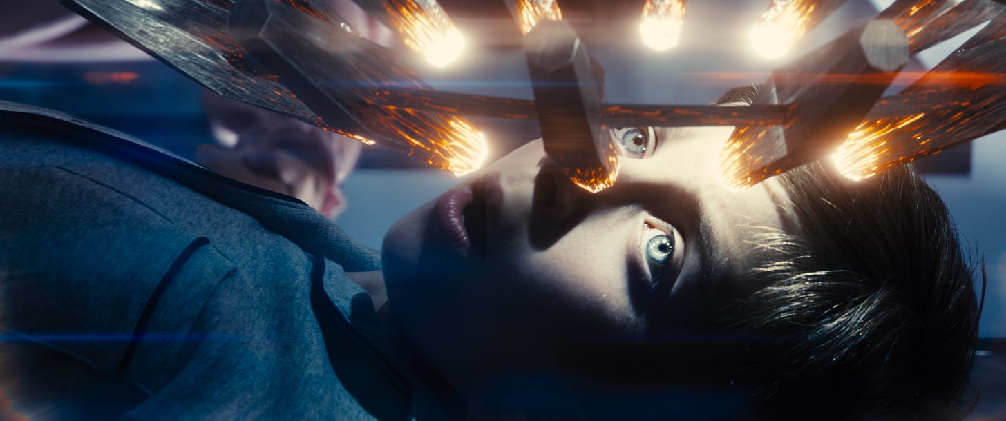 A young boy lies on a table with alien glowing devices hovering above in Disclosure Day. A young boy lies on a table with alien glowing devices hovering above in Disclosure Day.