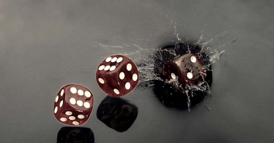 Red dice splashing into dark water