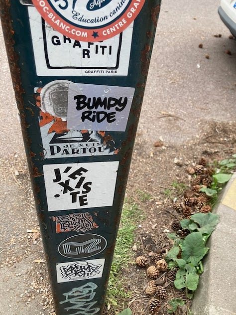 The J'existe sticker in three locations in Paris