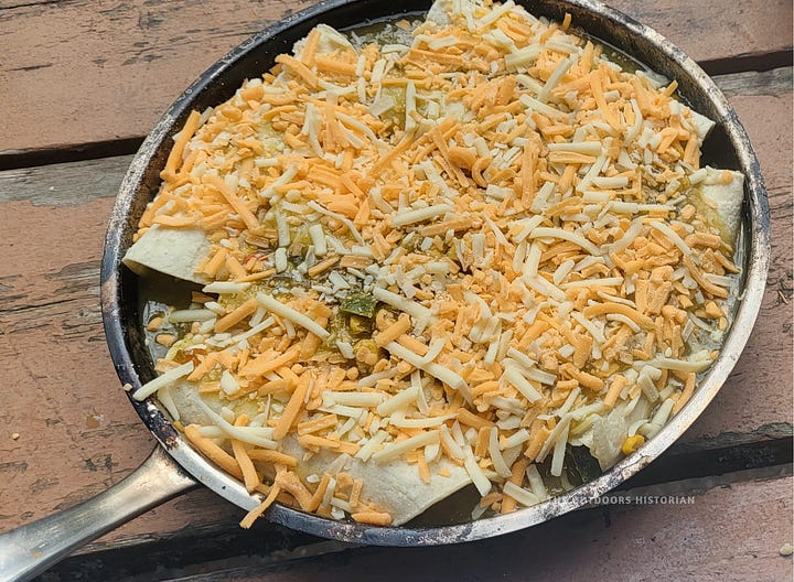 A four-photo sequence of campfire chicken enchiladas: raw ingredients on a picnic table, the assembled pan topped with shredded cheese, the bubbling finished dish, and a final serving on a plate.