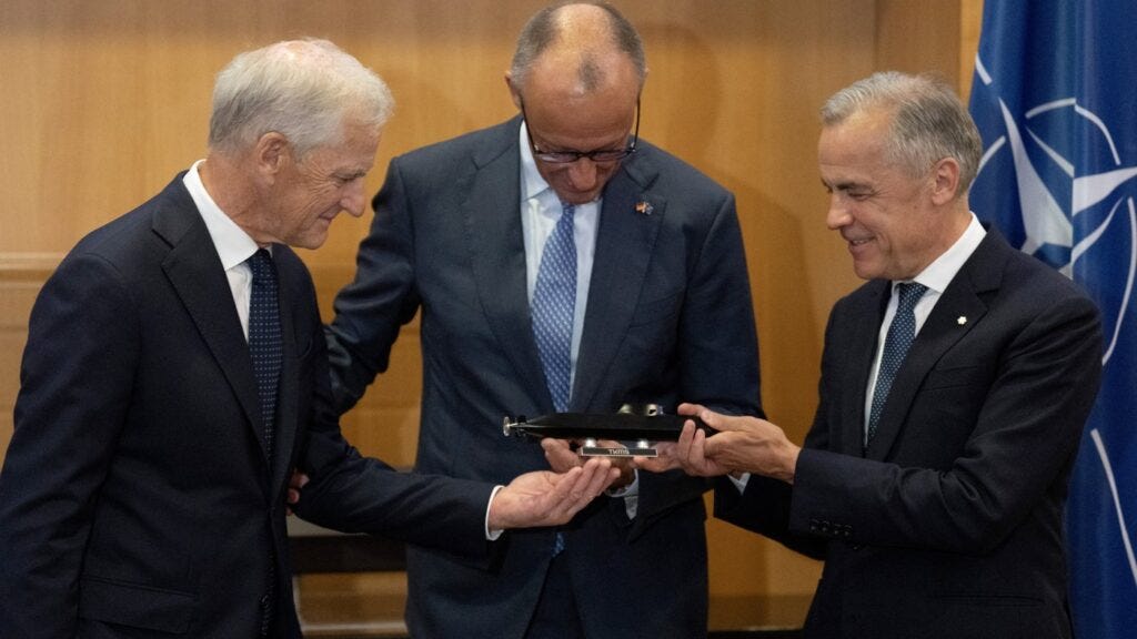 Prime Minister Mark Carney, right, German Chancellor Friedrich Merz, centre, and Norwegian Prime Minister Jonas Gahr Store examine a small model of a TKMS submarine before meeting in Ankara, Turkey, Tuesday, July 7, 2026. THE CANADIAN PRESS/Adrian Wyld 