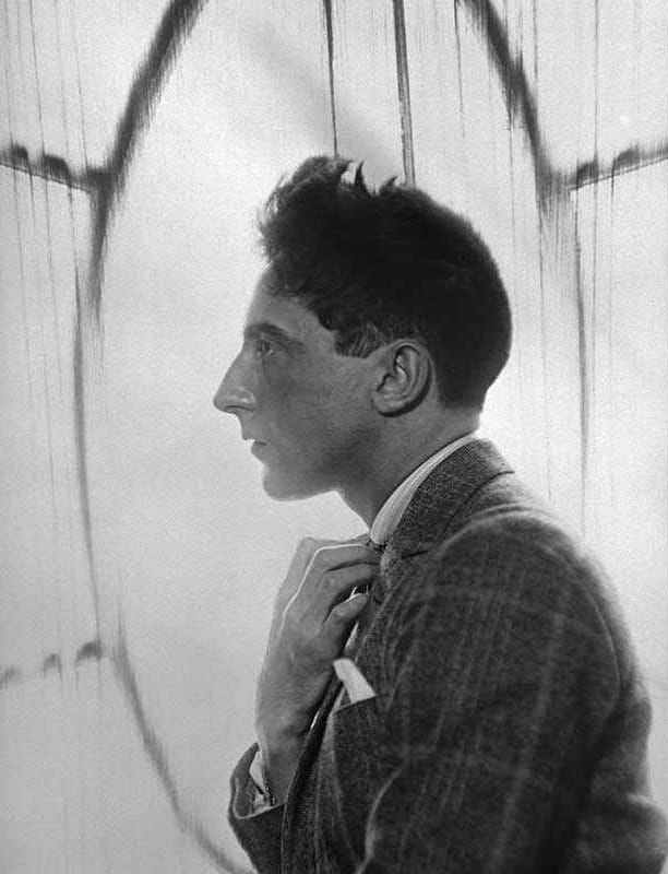Jean Cocteau profile portrait man backlighting hand on shirt's neck...