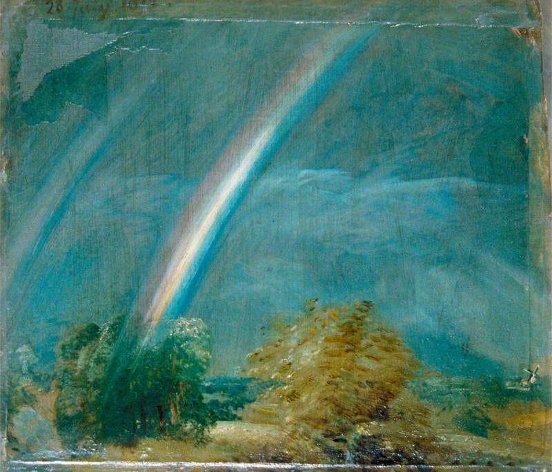 A double rainbow over green fields under fast moving grey and gold storm clouds A double rainbow over green fields under fast moving grey and gold storm clouds