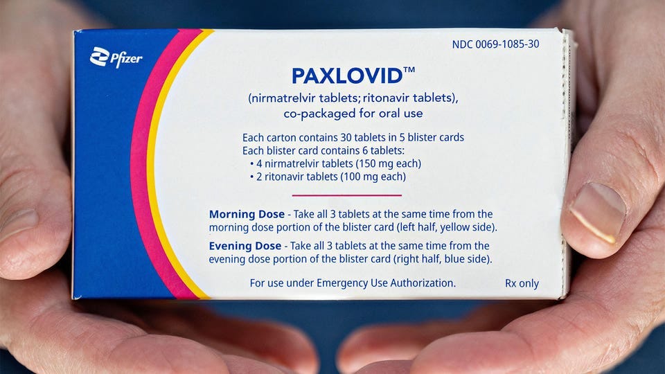 A close up photo of a man holding a box of Paxlovid. A close up photo of a man holding a box of Paxlovid.