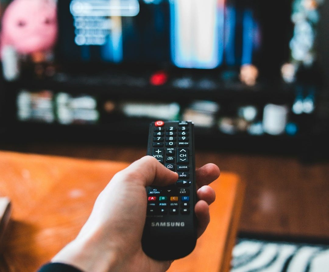 person holding black remote control person holding black remote control