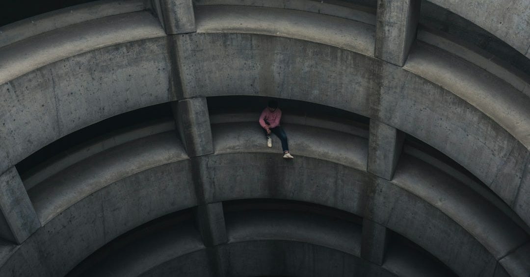 person in red jacket walking on brown tunnel person in red jacket walking on brown tunnel