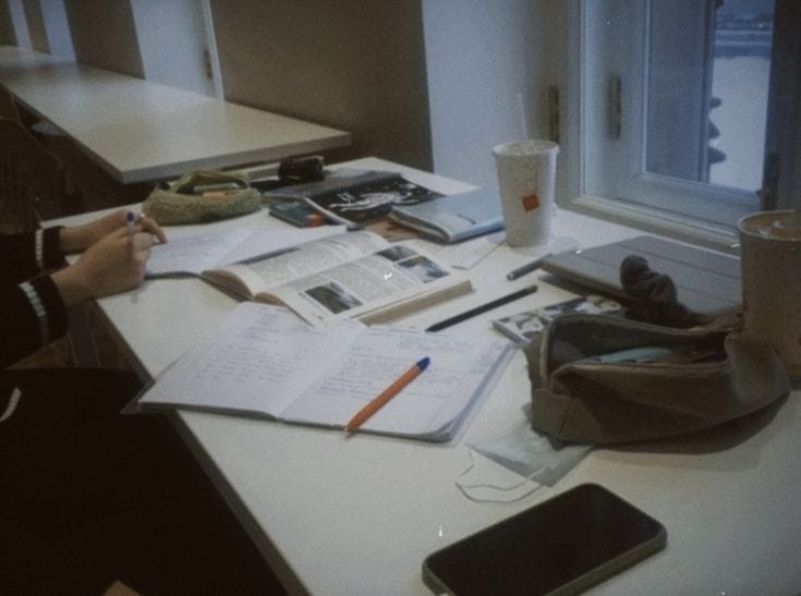 This may contain: a person sitting at a desk with papers and cell phone This may contain: a person sitting at a desk with papers and cell phone