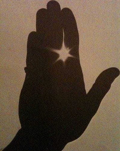 silhouette of a hand in front of the sun