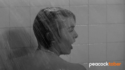 Close-up black-and-white image of a woman screaming dramatically in the shower from the classic horror movie Psycho, capturing the absolute panic of midlife hair loss. Close-up black-and-white image of a woman screaming dramatically in the shower from the classic horror movie Psycho, capturing the absolute panic of midlife hair loss.