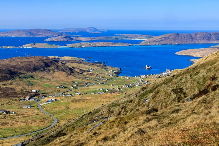 Madonna and Child statue on the shoulder of Heabhal on Barra and the view to Castlebay from it © Felicity Martin