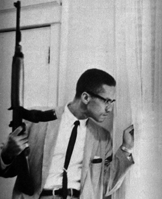 Malcolm X peering out the window of his home while carrying a rifle, 1964  (571x699) : r/HistoryPorn