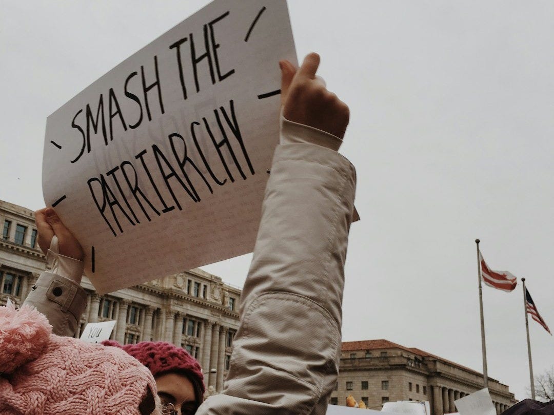 woman holding white paper with smash the pairtarchy