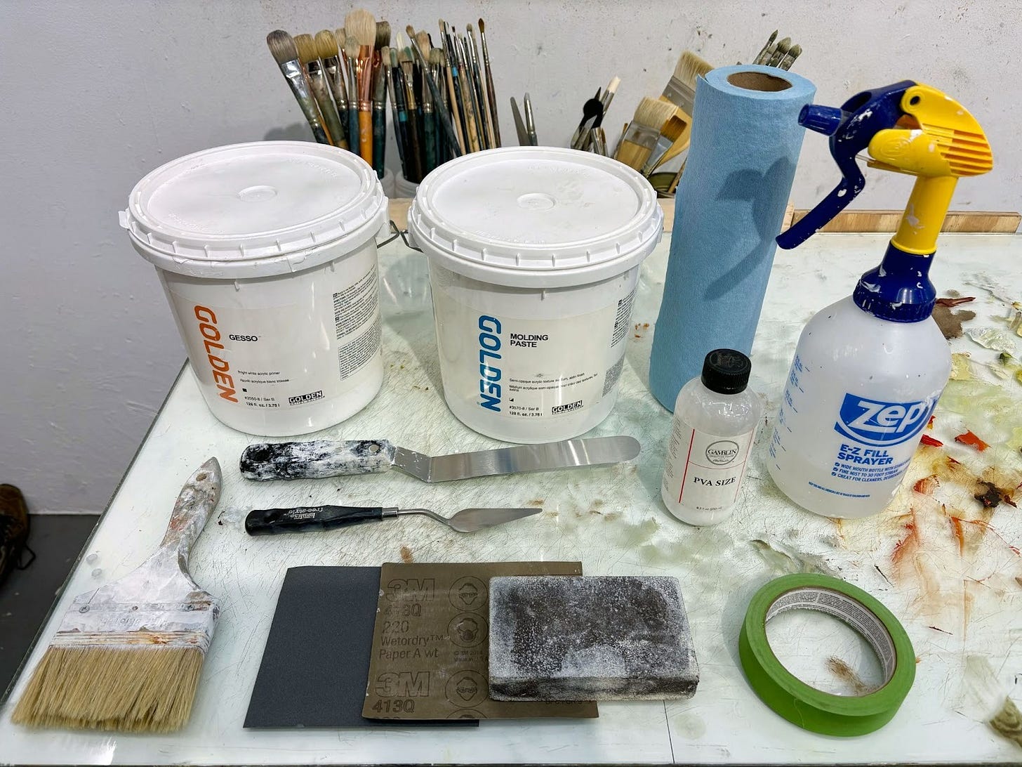 All items needed to create a molding past ground are laid out neatly on a studio table.