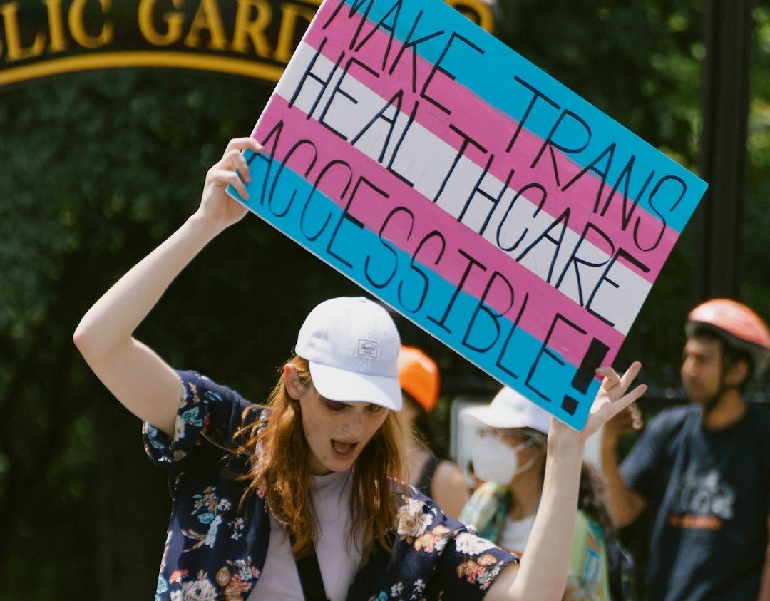 a woman holding a sign in front of a group of people