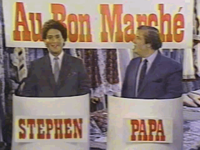 two men standing in front of a sign that says au bon marche on it two men standing in front of a sign that says au bon marche on it